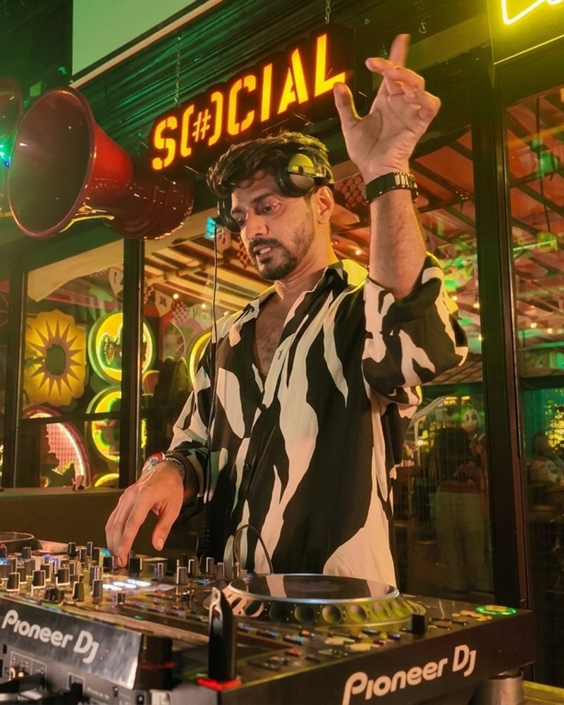 Aryan mixing under the neon Social sign